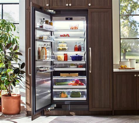 fisher & paykel panel ready refrigerator installed nexted to reform cabinetry for a modern sleek kitchen. 